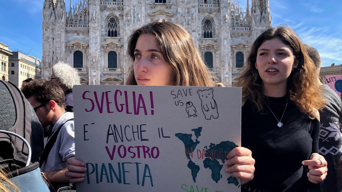 1140X641_attivista Milano con cartello e Duomo.jpg